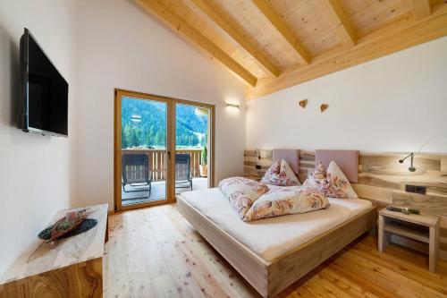 a bedroom with a couch and a television in a room at Masi Lavendel in Santa Valburga St. Walburg