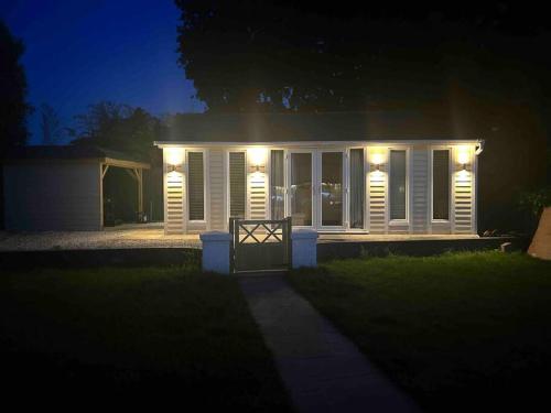 a house with lights on the front of it at night at Lovely studio cabin. Hot tub ex £40 per night in Poole