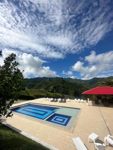 a swimming pool with chairs and a blue sky at FINCA LAS MARÍAS 2 in Vergara