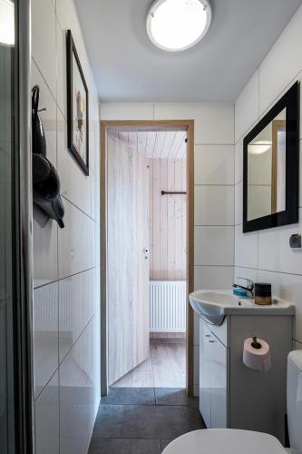 a white bathroom with a sink and a toilet at Domki EVITA in Władysławowo