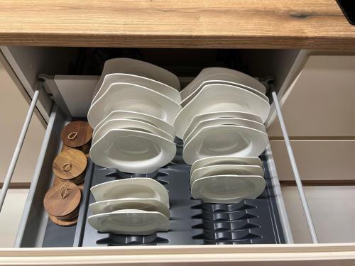 a drawer filled with white dishes and wooden slices at Luxe Living Stara Pazova in Stara Pazova