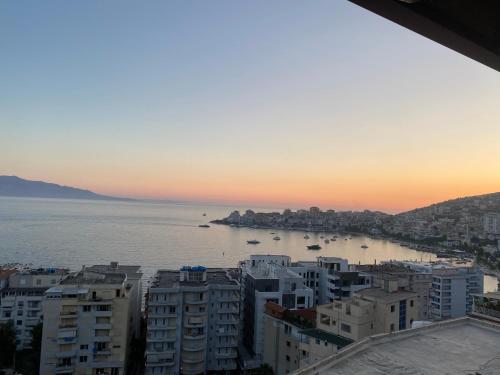 a view of the ocean from a city at sunset at Blue Breeze Attic Apartments in Sarandë