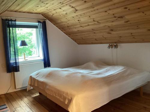 uma cama num quarto com tecto em madeira em Holiday home MOTALA VI em Motala