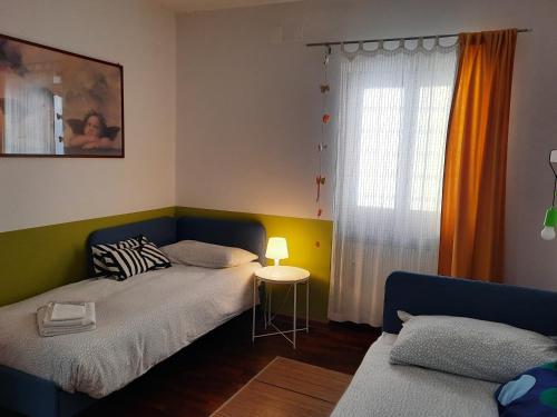 um pequeno quarto com 2 camas e uma janela em Un Patio in centro em Perugia