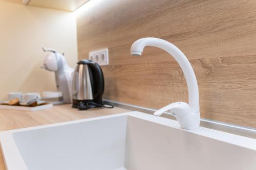 a kitchen sink with two white faucets on a counter at City center 2-Bedroom Apartment in Plovdiv