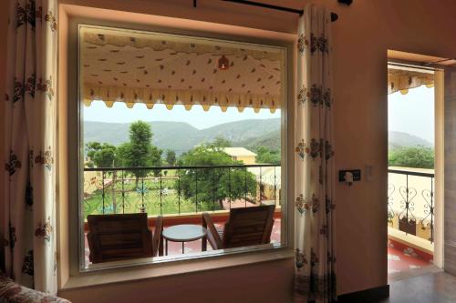 a large window with a view of a balcony at Ratan Villas Sariska in Alwar