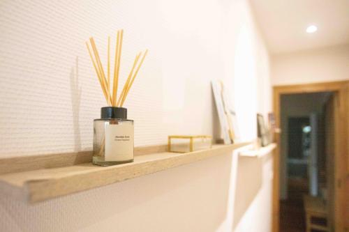 a bottle of perfume sitting on a shelf in a bathroom at Le Nid du Cap à proximité de la plage in Lège-Cap-Ferret