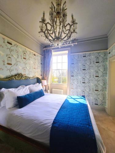 a bedroom with a large bed and a chandelier at Newton Hall in Chathill