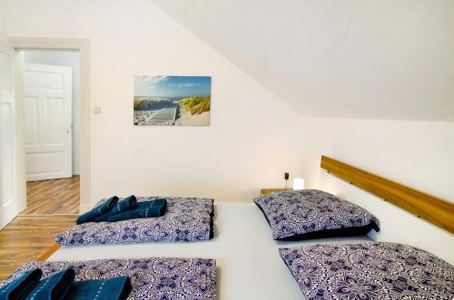 two beds in a white room with blue pillows at Villa Fokken Bootsmannsquartier in Esens
