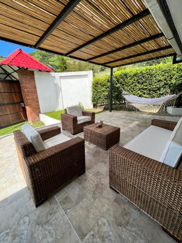 a patio with wicker furniture and a hammock at FINCA LAS MARÍAS 2 in Vergara