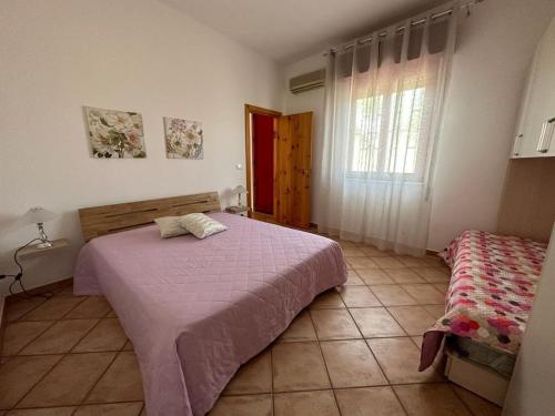 een slaapkamer met een bed en een raam bij Il sentiero delle palme in Comiso