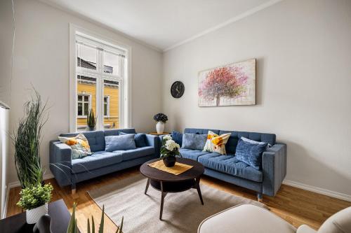 ein Wohnzimmer mit einem blauen Sofa und einem Tisch in der Unterkunft Rosen Apartment in Bergen