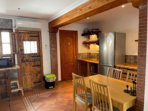 Il comprend une cuisine équipée d'une table en bois et d'un réfrigérateur. dans l'établissement Casa Calderón, à Marbella