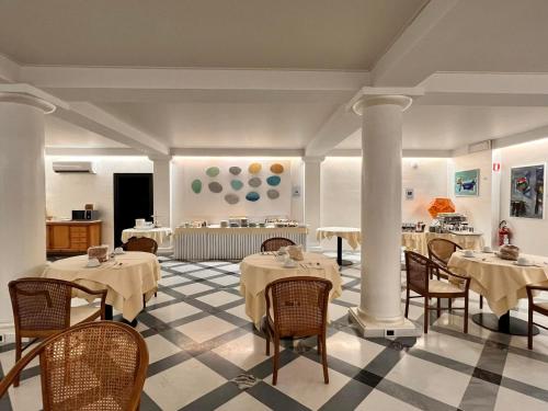 a restaurant with tables and chairs in a room at Arthotel Gabbiano Azzurro Due in Marciana Marina