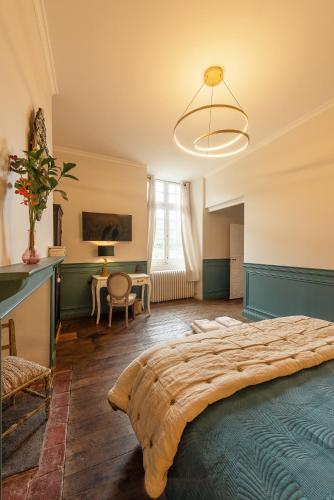 a bedroom with a large bed and a desk at Manoir de Laroque Delprat in Autoire