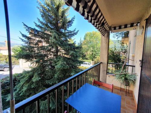 a blue table on a balcony with a christmas tree at Le confort au coeur des Alpes du Sud + parking in Gap