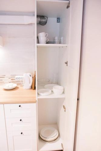 a closet with white cabinets and a toilet at Aizpuri West View in Nīca