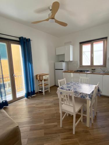 ein Wohnzimmer mit einem Tisch und einer Küche in der Unterkunft Casa Gina e Pietro in Ustica