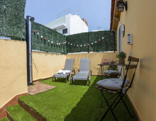 eine Terrasse mit 2 Stühlen, einem Tisch und Gras in der Unterkunft LOFT en zona Puerto Las Palmas de Gran Canaria in Las Palmas de Gran Canaria