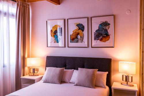 ein Schlafzimmer mit einem Bett mit drei Bildern an der Wand in der Unterkunft LOFT en zona Puerto Las Palmas de Gran Canaria in Las Palmas de Gran Canaria