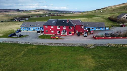 an aerial view of a large red house in a field at Herrislea House Hotel in Tingwall