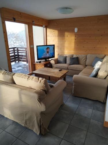 a living room with couches and a flat screen tv at LA PLAGNE MONTALBERT Chalet - fitness - wifi in Montgésin