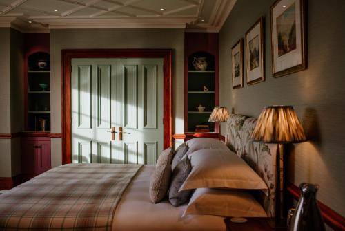 a bedroom with a bed with two lamps and a window at Links House at Royal Dornoch in Dornoch