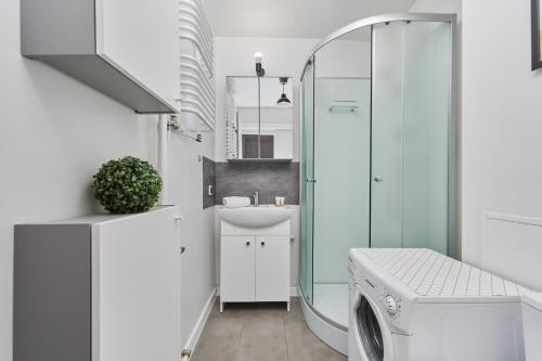 a bathroom with a sink and a washing machine at Studio with Sky Tower View Wrocław by Renters in Wrocław
