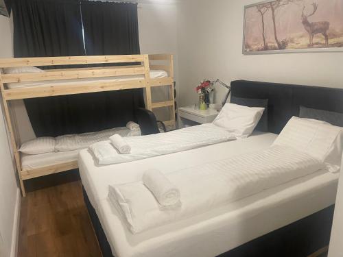a bedroom with two bunk beds with white sheets at Hechtplatz Hotel - Self Check-in in Zürich