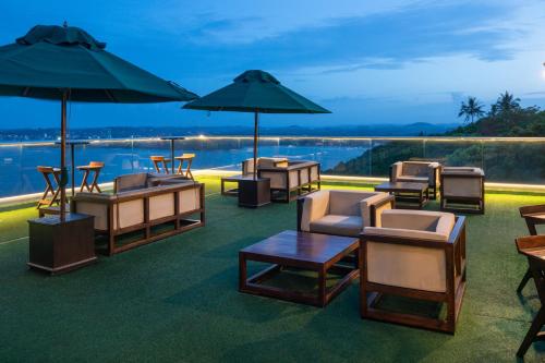 a patio with chairs and tables and umbrellas at Agnus Unawatuna in Unawatuna