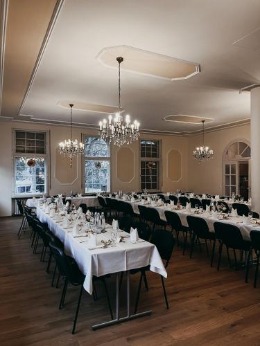 a banquet hall with tables and chairs and chandeliers at Hotel Bayerischer Hof in Bad Kissingen
