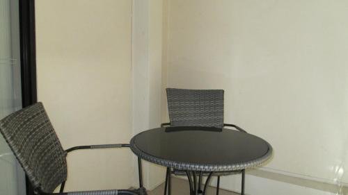 a table and two chairs in a room at Edge Apartments Cairns in Cairns