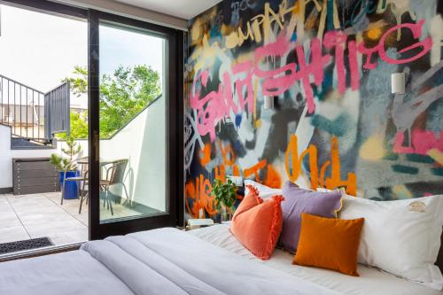 a bedroom with a wall covered in graffiti at ArtSquare Fragola Apartments in Kraków