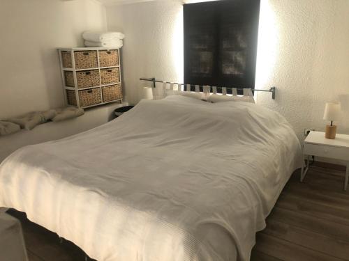 - un grand lit blanc dans une chambre avec une table dans l'établissement La Voile Blanche -Port-Grimaud Lux, à Grimaud