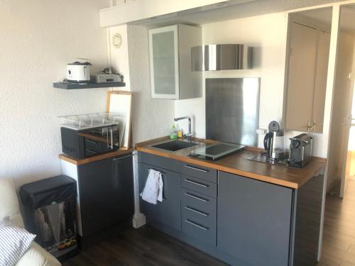 une petite cuisine avec un évier et un comptoir dans l'établissement La Voile Blanche -Port-Grimaud Lux, à Grimaud