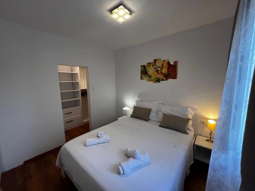 a bedroom with a white bed with towels on it at Apartments Village in Lozovac