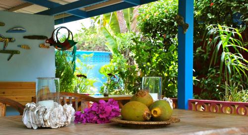 a wooden table with a bowl of fruit on it at Caribbean Flower Apartments in Willemstad