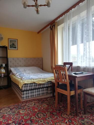 a bedroom with a bed and a desk and a chair at U Sowy in Kołobrzeg