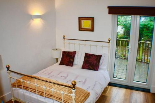 a bedroom with a bed with white sheets and red pillows at Mount Barn in Newcastle Emlyn
