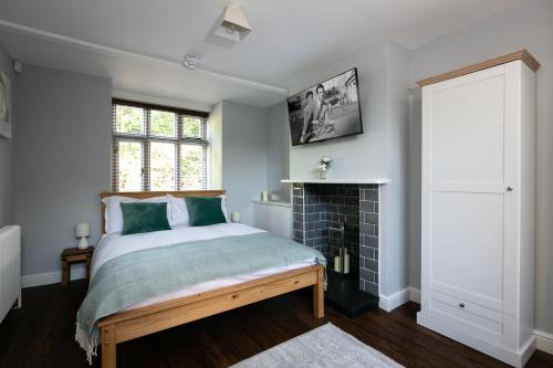Accommodation at Salomons Estate في رويال تونبريدج ويلز: غرفة نوم بسرير ومدفأة