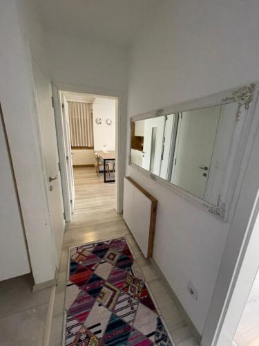 a hallway with a mirror and a rug at Plis Apartment II in Pristina