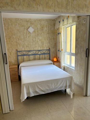 Schlafzimmer mit einem Bett und einem Fenster in der Unterkunft Apartamento BuenasVistas in Algarrobo-Costa