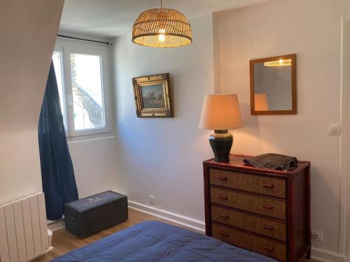 - une chambre avec un lit et une commode avec une lampe dans l'établissement Confort et charme des 70's dans le centre piéton, à Vannes