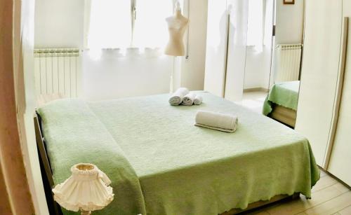 Un dormitorio con una cama verde con toallas. en Venezia House, en Ladispoli