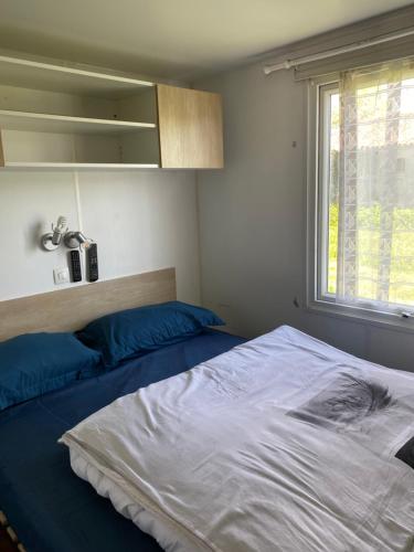 a bedroom with two beds and a window at Mobil home camping privé in Saint-Laurent-de-la-Prée