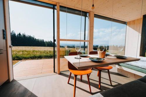 a room with a table and chairs and a large window at TinyHouse Rumcajs in Malšín