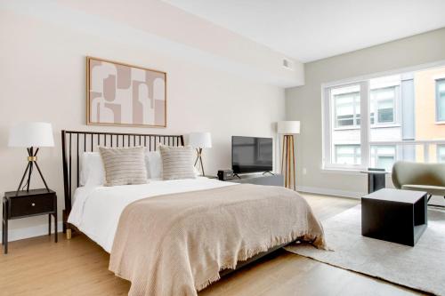 a white bedroom with a bed and a chair at Mt Vernon Studio w Pool WD Gym nr Metro WDC-530 in Washington, D.C.