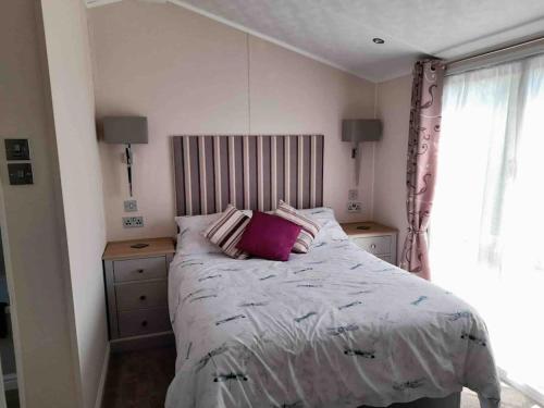 um quarto com uma cama com duas almofadas em Pebble Lodge em Tydd Saint Giles