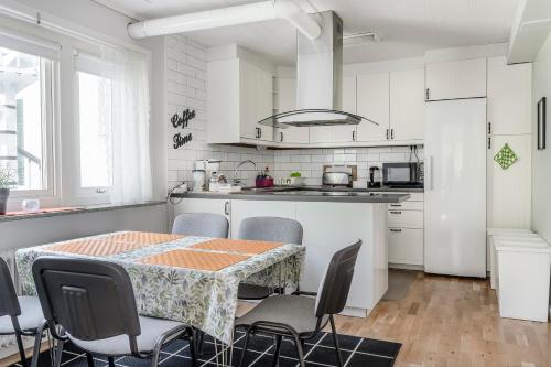 a white kitchen with a table and chairs at Vandrarhemmet Stranden in Mora