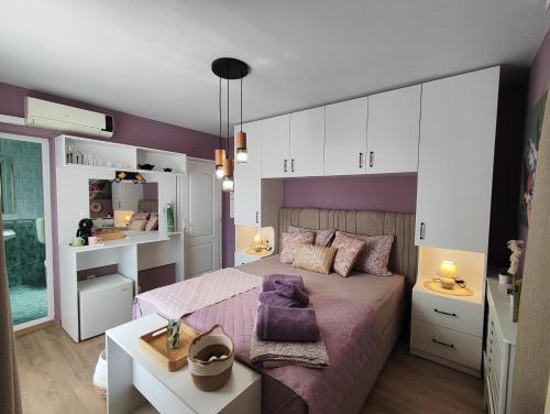 a bedroom with a bed and a purple wall at AMORE Obzor in Obzor